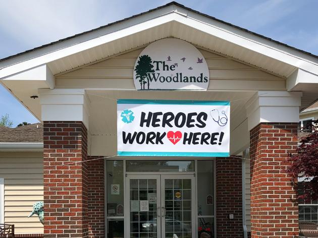 woodlands entrance with "Heroes work here!" sign over door